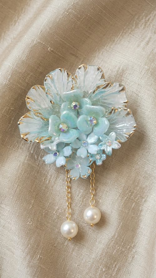 Decorative brooch with floral design and pearl accents on a beige background
 Aqua Cascade & Pearl Dangle Hair
