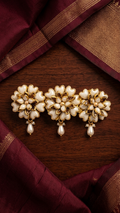 Pure Pearl & Crystal Lotus Kundan Centre Clip

Decorative hair clip with pearls on a wooden surface with fabric background